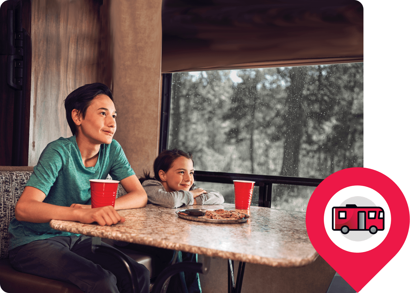 Kids sitting at table in an RV watching television.